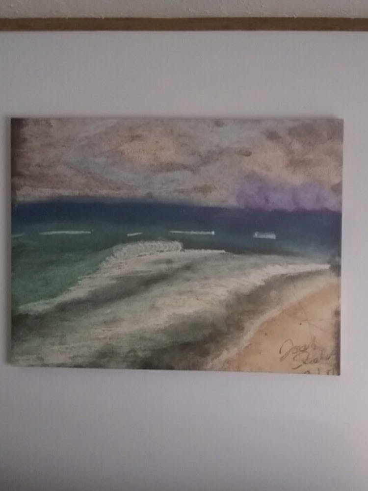 Painting of the ocean lapping the shore.
