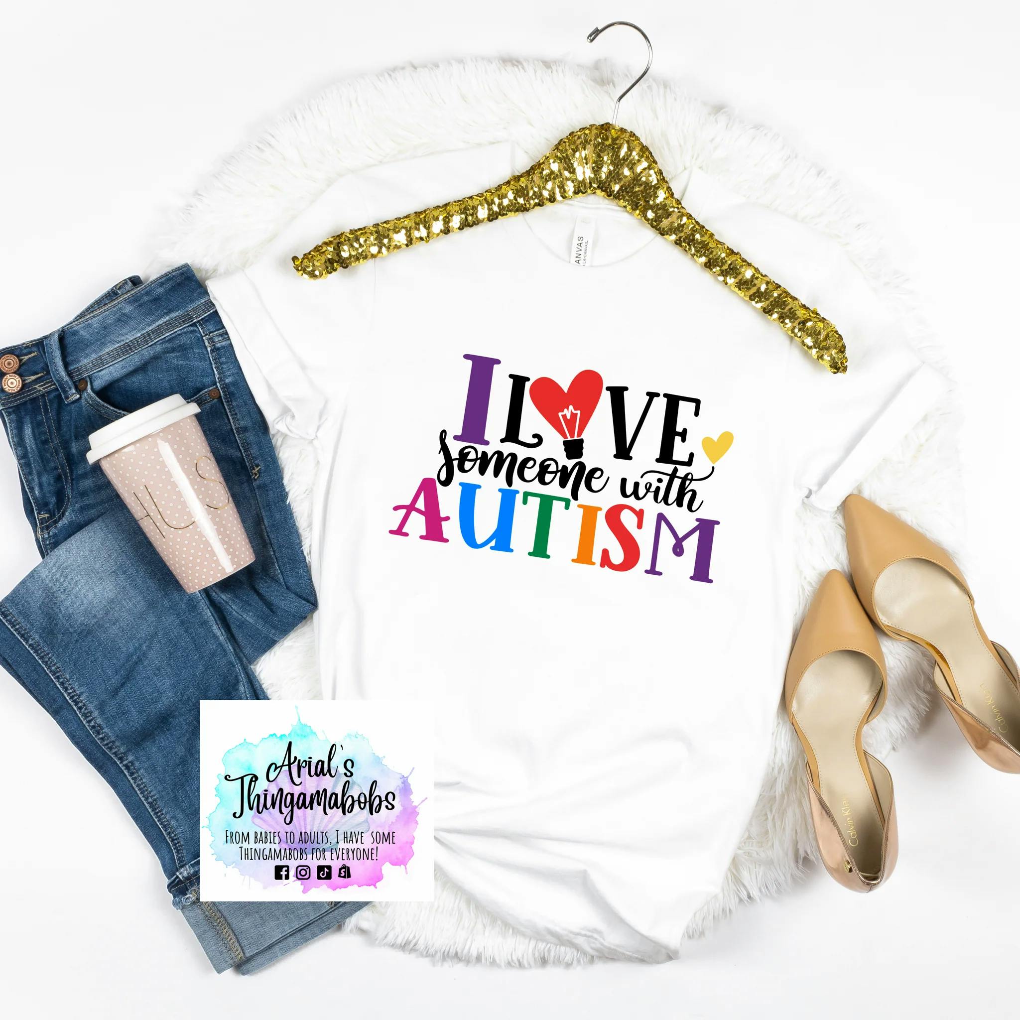Autism Rocks and Rolls t-shirt. Displays the text "I Love Someone With Autism" in colorful lettering. The O in Love is a heart.
